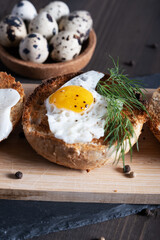 Fried quail egg baked in a round bun with dill