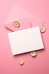 Invitation or greeting card mockup with envelope and daisy flowers