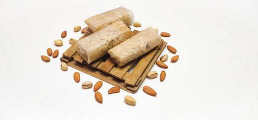 Closeup of South Indian traditional dish or Sweet pootharekelu made with rice floor, ghee and dry fruits. Isolated in a White background with selective focus and copy space for inscription. 