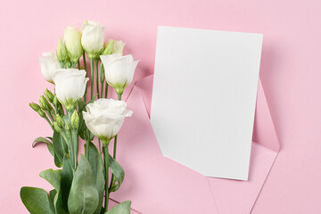Invitation or greeting card mockup with envelope and white eustoma flowers