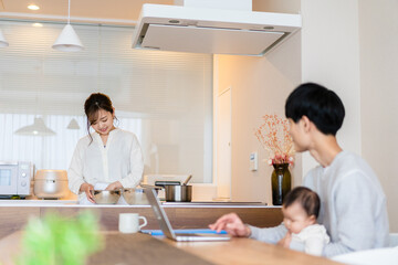 赤ちゃんと一緒にパソコンを使うパパ