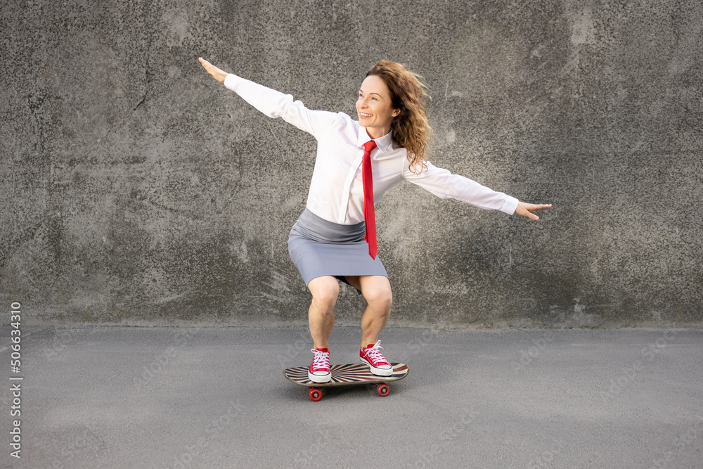 Wall mural funny businesswoman riding skateboard outdoor