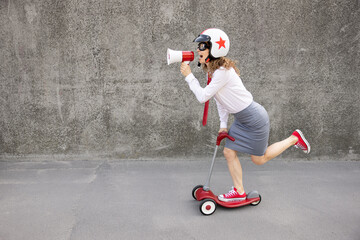 Funny businesswoman riding scooter outdoor