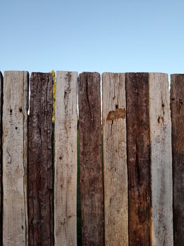 Cerco de tablones de madera de Quebracho sudamericano en el campo rural, de color blanco y marr&ograve;n alineados en forma de valla, forma un bello dise&ntilde;o abstracto natural con fondo del cielo azul