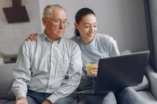 Girl Teaching Her Grandfather How To Use A Laptop