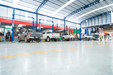 Blurred background of Car repair station paved with epoxy floor and electric lift for a car that...