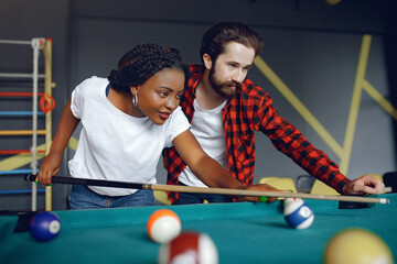Fototapeta premium International couple playing a billiard in a club