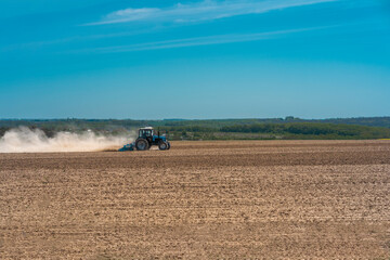 Fototapeta na wymiar spring sowing agricultural crops, tractor works on the field ukraine agrarian sunny day