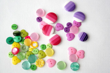 Many multi-colored funny buttons on a white background. Buttons for sewing clothes and needlework.