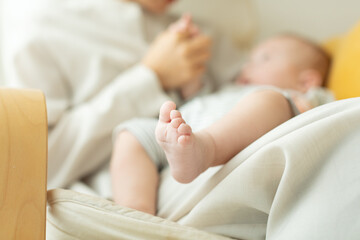赤ちゃんの足を握る母親の手元