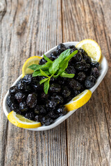 Black olive. Natural black olive on wood floor background. Healthy food. close up