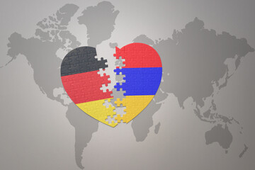 puzzle heart with the national flag of armenia and germany on a world map background. Concept.