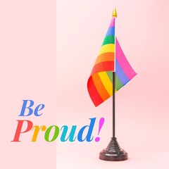 Digital be proud text with rainbow flag against pink background