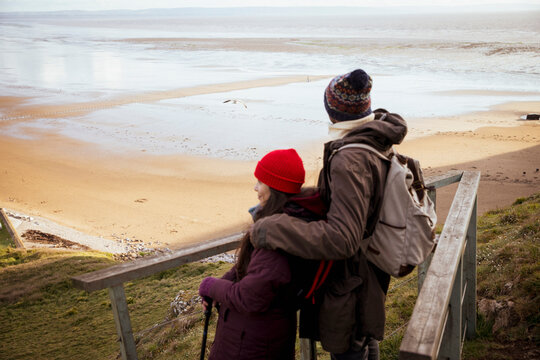 Hiker Couple On Cliff Above Ocean Beach