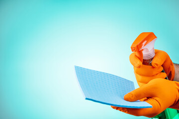 man with rubber gloves and spray bottle on green background. copy space. cleaning service concept.