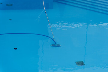 Fototapeta na wymiar Cleaning pool with special device and hose.