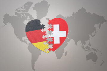 puzzle heart with the national flag of switzerland and germany on a world map background. Concept.