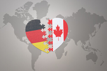 puzzle heart with the national flag of canada and germany on a world map background. Concept.