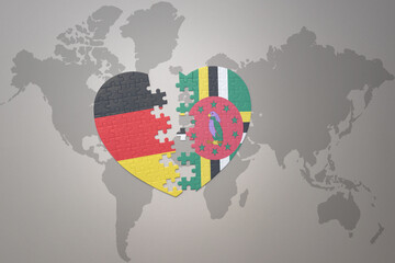 puzzle heart with the national flag of dominica and germany on a world map background. Concept.