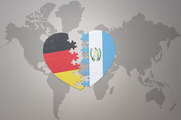 Fototapeta premium puzzle heart with the national flag of guatemala and germany on a world map background. Concept.