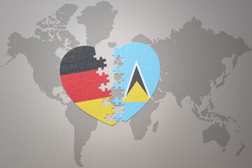 puzzle heart with the national flag of saint lucia and germany on a world map background. Concept.