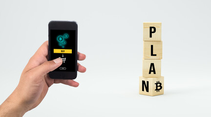 cubes with message PLAN ₿ and hand with smartphone ready to buy crypto on white background