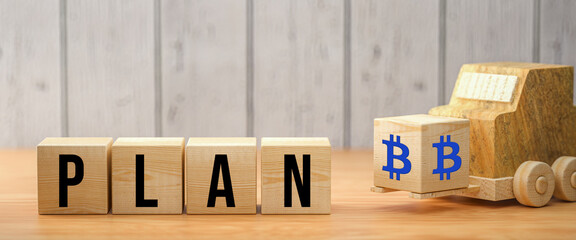 cubes with message PLAN ₿ on wooden surface