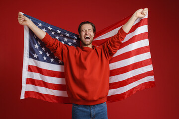 Young bristle man screaming while posing american flag