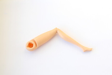 Leg from a doll. Plastic detail from Barbie doll. Broken toy.