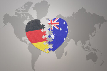puzzle heart with the national flag of australia and germany on a world map background. Concept.