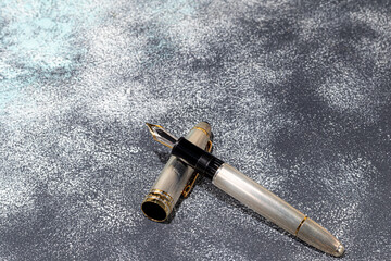 Fototapeta na wymiar Fountain pen on a marble and gray background. Selective focus.