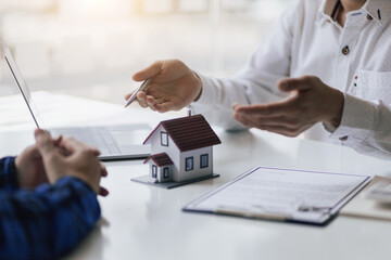 Real estate agents negotiate the terms of the home purchase contract and sign the contract legally. Home insurance concept.