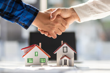 Real estate agents shake hands after the signing of the contract agreement is complete.