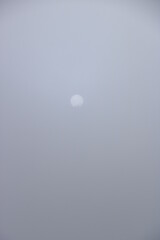 le disque de l'astre solaire dans la brume matinale en montagne, jour blanc  