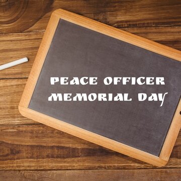 Digital composite image of peace officer memorial day text on writing slate over table