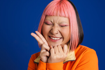 Asian girl with pink hair laughing while showing peace gesture