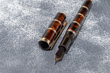 Fountain pen on a marble and gray background. Selective focus.