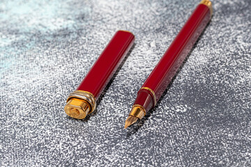 Fountain pen on a marble and gray background. Selective focus.