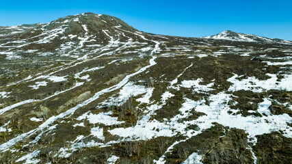 Last snow is melting on hillside of Scandinavian mountains 