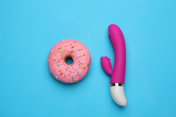 Pink vaginal vibrator and donut on light blue background, flat lay - obrazy, fototapety, plakaty