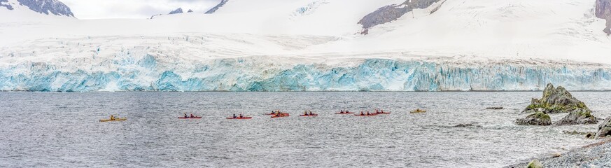 Kajakfahren im Winter in der Antarktis. Extremsport-Abenteuer. Touristen  paddeln mit dem Kajak auf Half Moon Island auf den Süd-Shettland-Inseln vor den blauen Gletschern der der Antarktis