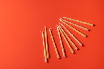 Festive composition with traditional Jewish candles for the Hanukkah holiday on red background.