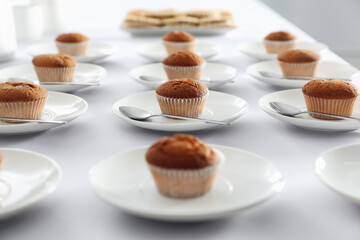 Many delicious muffins served on white table for coffee break