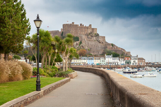 UK - Jersey - The massive Gorey castle atop of mont Orgueil along with Gorey pier and harbour taken from Gorey promenade on a stormy day