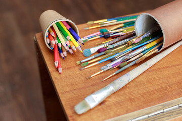 Obraz premium paint brushes and artist pencils on the desktop close-up
