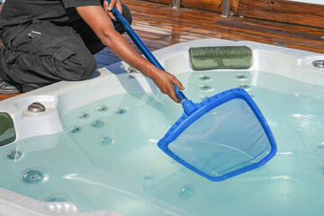 Hand of african maintenance hotel staff worker cleaning hot tub