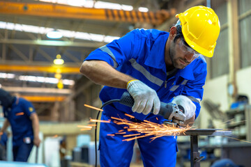 Industrial worker using angle grinder and cutting a metal.