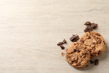 Delicious chocolate chip cookies on wooden table, flat lay. Space for text