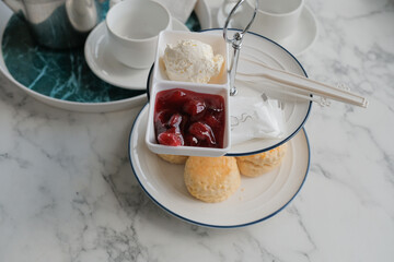 Tea with scones and clotted cream, jam, strawberries on the white table