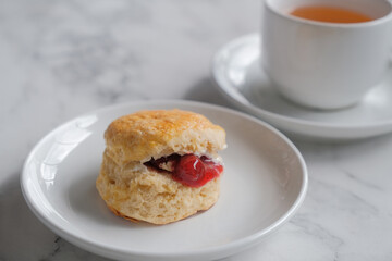 Tea with scones and clotted cream, jam, strawberries on the white table